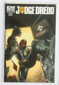A comic book  titled 'Judge Dredd' with cover art showing a futuristic armored figure in a dramatic scene, photographed inside a clear protective sleeve on a white background.